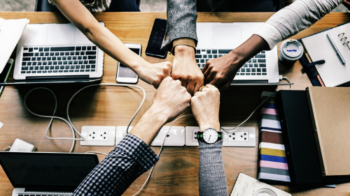 team work , hands around computers