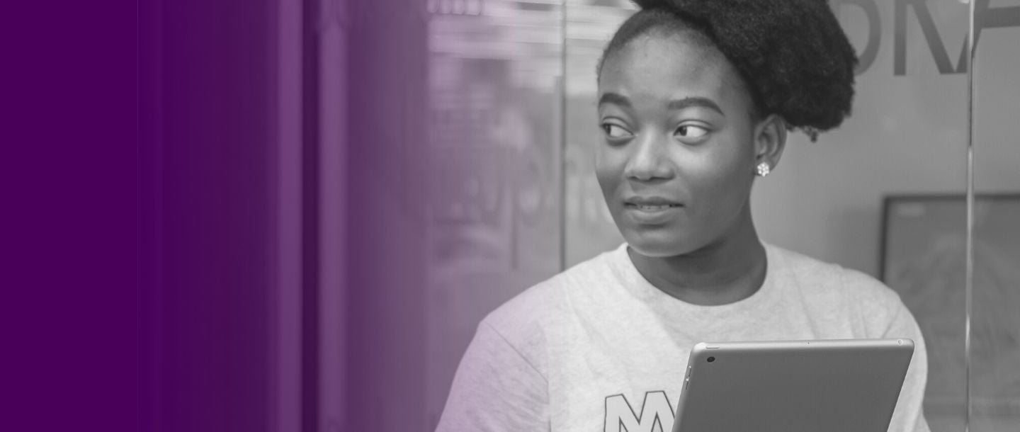 Grayscale image of girl holding a tablet and looking to the side. Purple gradient effect.