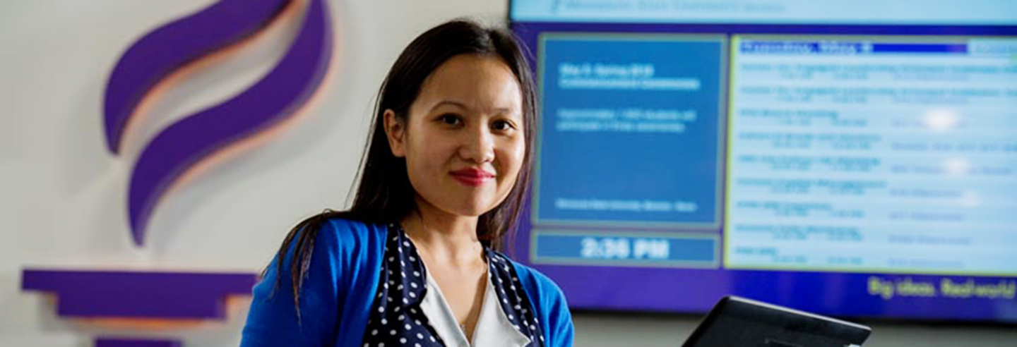 Girl using laptop and posing with a smile