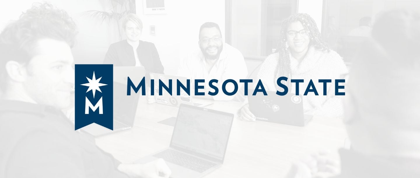 A team at work using laptops in a meeting room. Minnesota State logo.