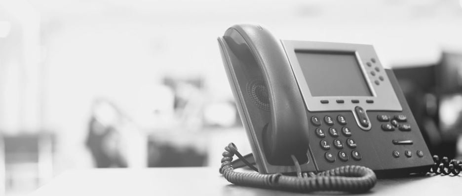 A Cisco phone on a desk in an office setting