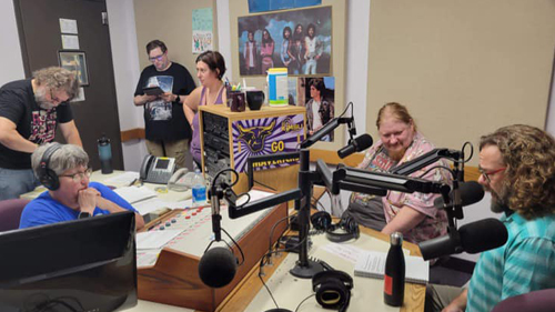 a group of people in a room with microphones