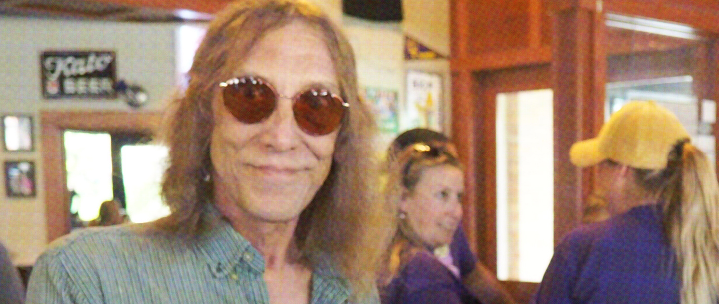 Reverend Dan Stelzer posing inside of a restaurant with three people in the background
