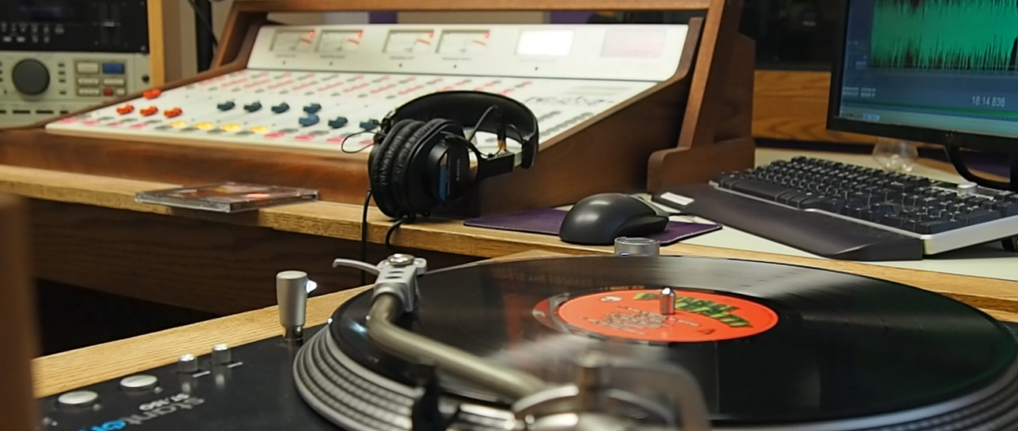 KMSU radio studio with an audio mixer, DJ set, headphone and a computer with a keyboard and mouse