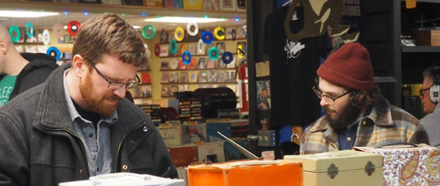 Steve Guse and Jameson Sweiger looking at record albums in a music store