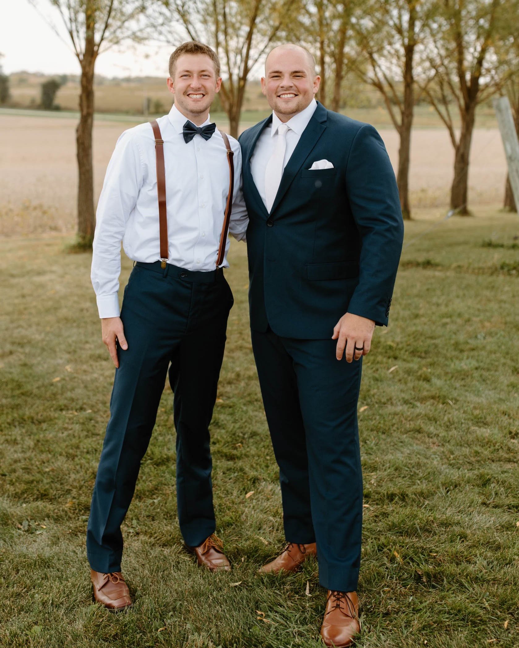 Matthew and Nathan at Nathan's wedding dressed in formal wear and big smiles on their faces.