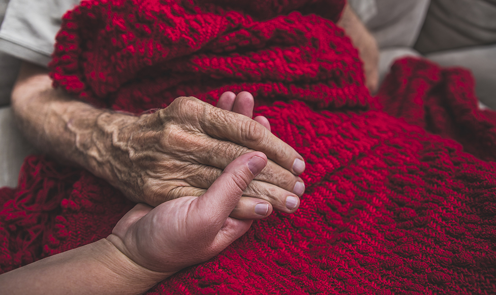 Elderly man and women holding hands, up close of just hands. 