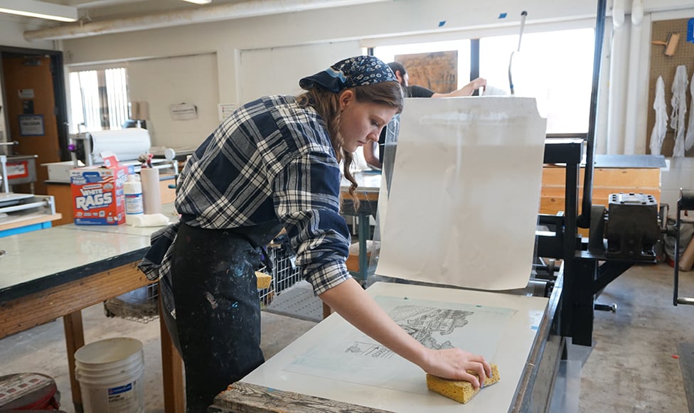 Female student preparing print making slide