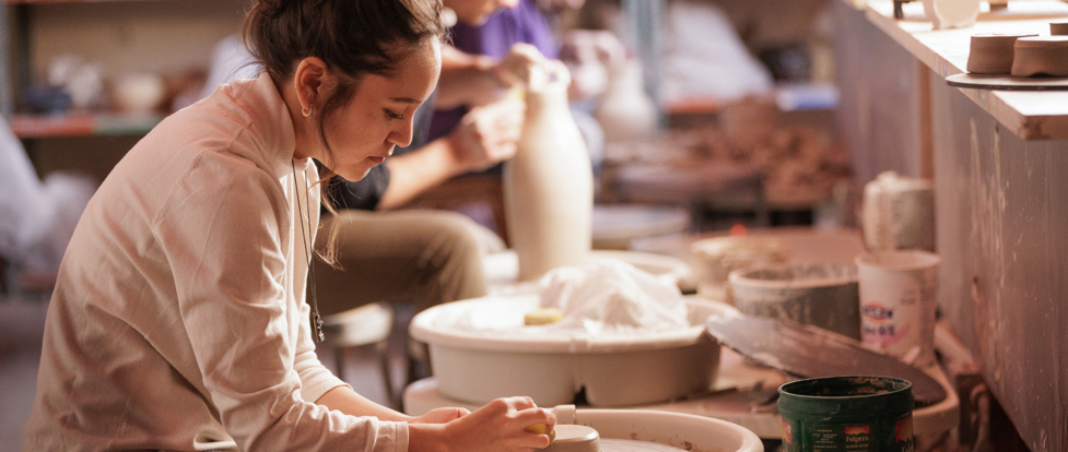 female student working with the ceramic wheel