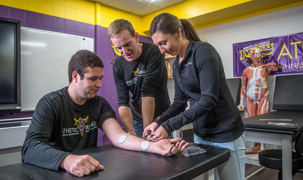 image of students learning to use tens pads from professor
