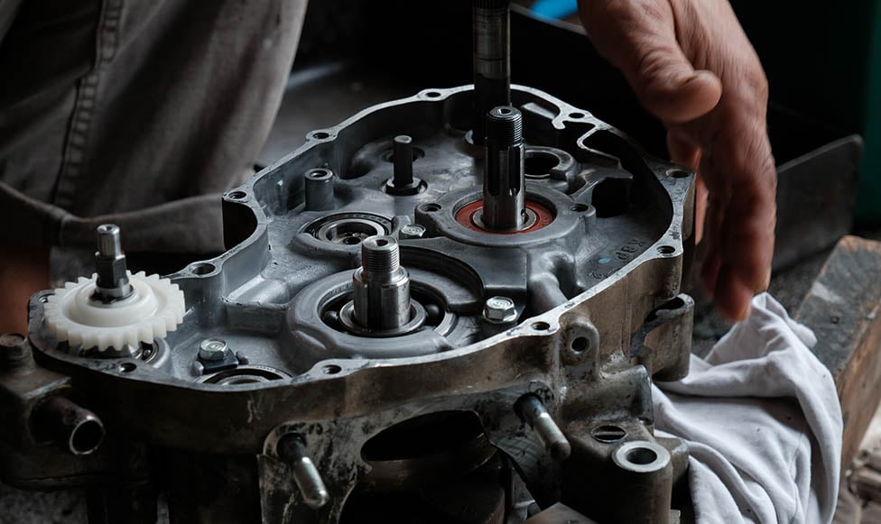 close up of a small motorcycle engine and someone testing it