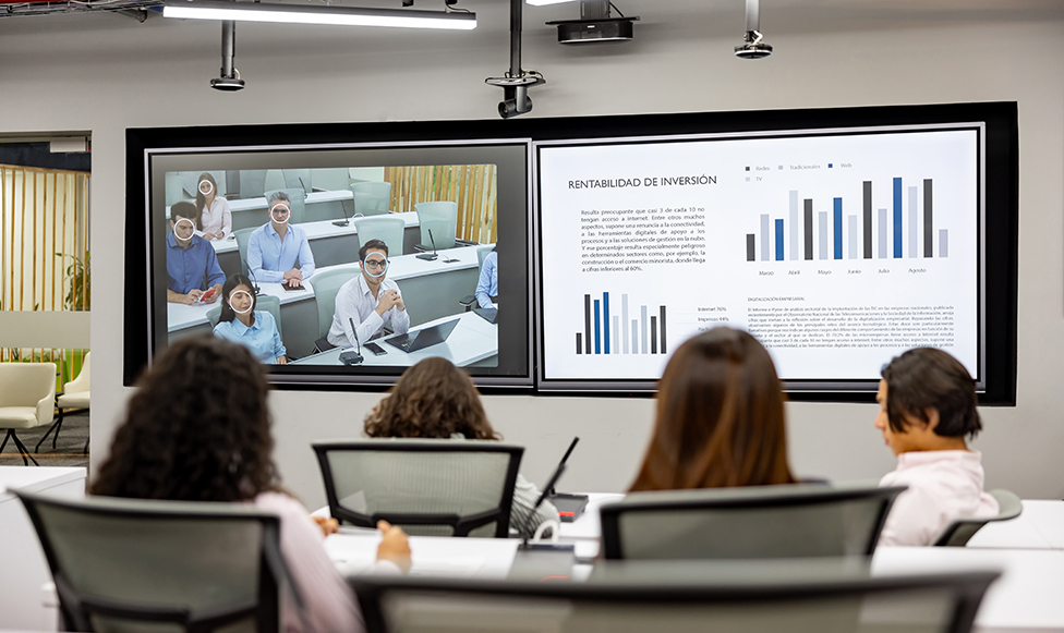 Meeting in a classroom, some people on the screen via zoom.