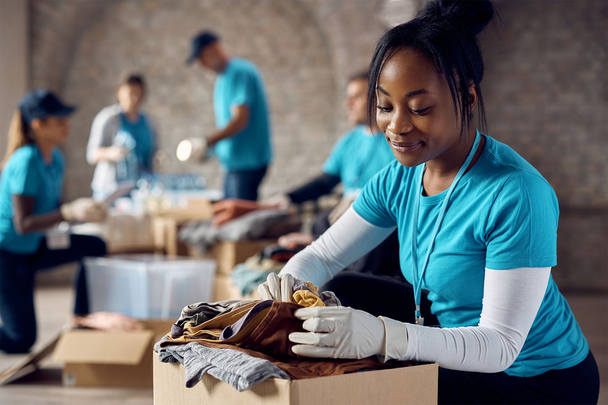 Women sorting through a box of clothes to donate. 