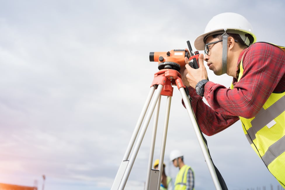 Engineer surveyor working at construction site.