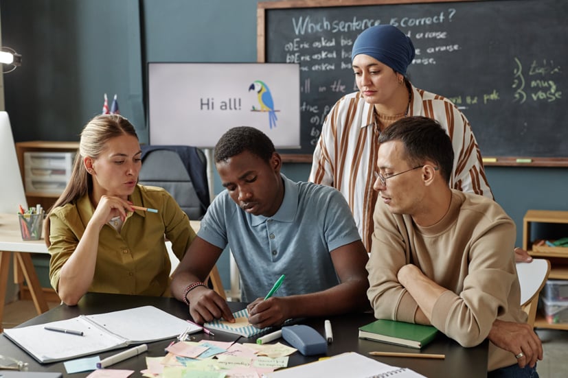Group of college kids or young adults sitting at a table learning.