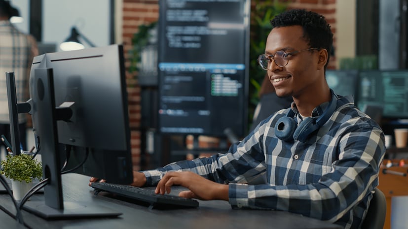 Software engineer sitting at a desk and writing code on computer.