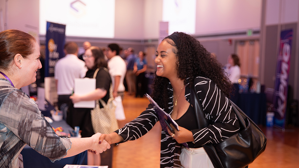 career fair student shaking hands with an employer