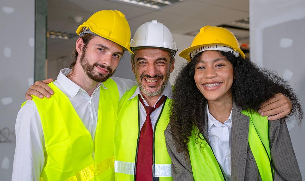 three construction management students in neon safety vests