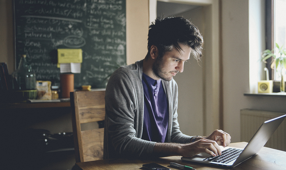 Man on computer typing.
