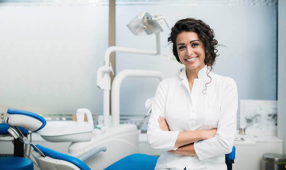 Dentist hygienist standing in front of a dental chair