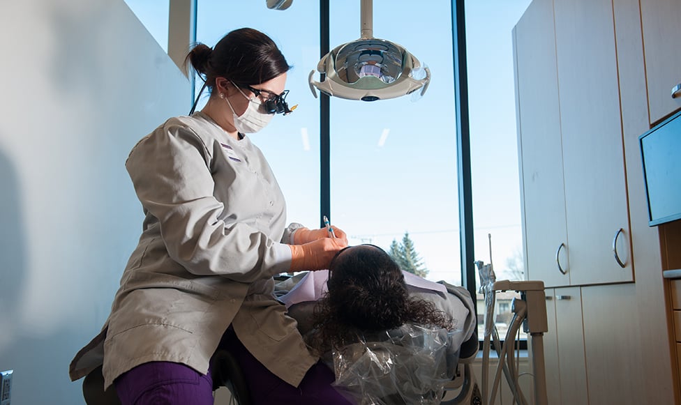 Dental professional working on a patient in the dental chair