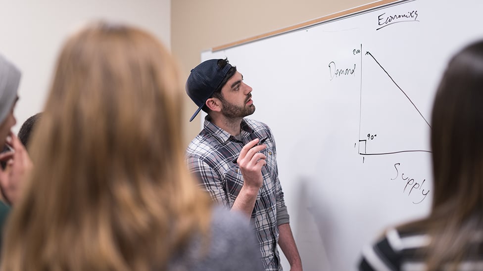 Economics professor showing work on the board