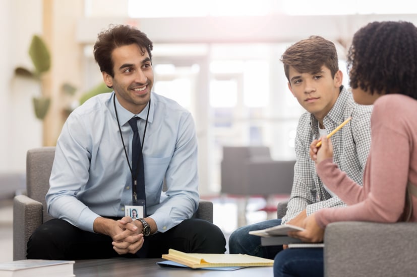 Man talking with student and parent. 