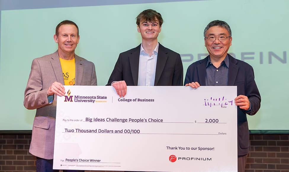 Big Ideas Challenge winner posing with a check college of business leadership