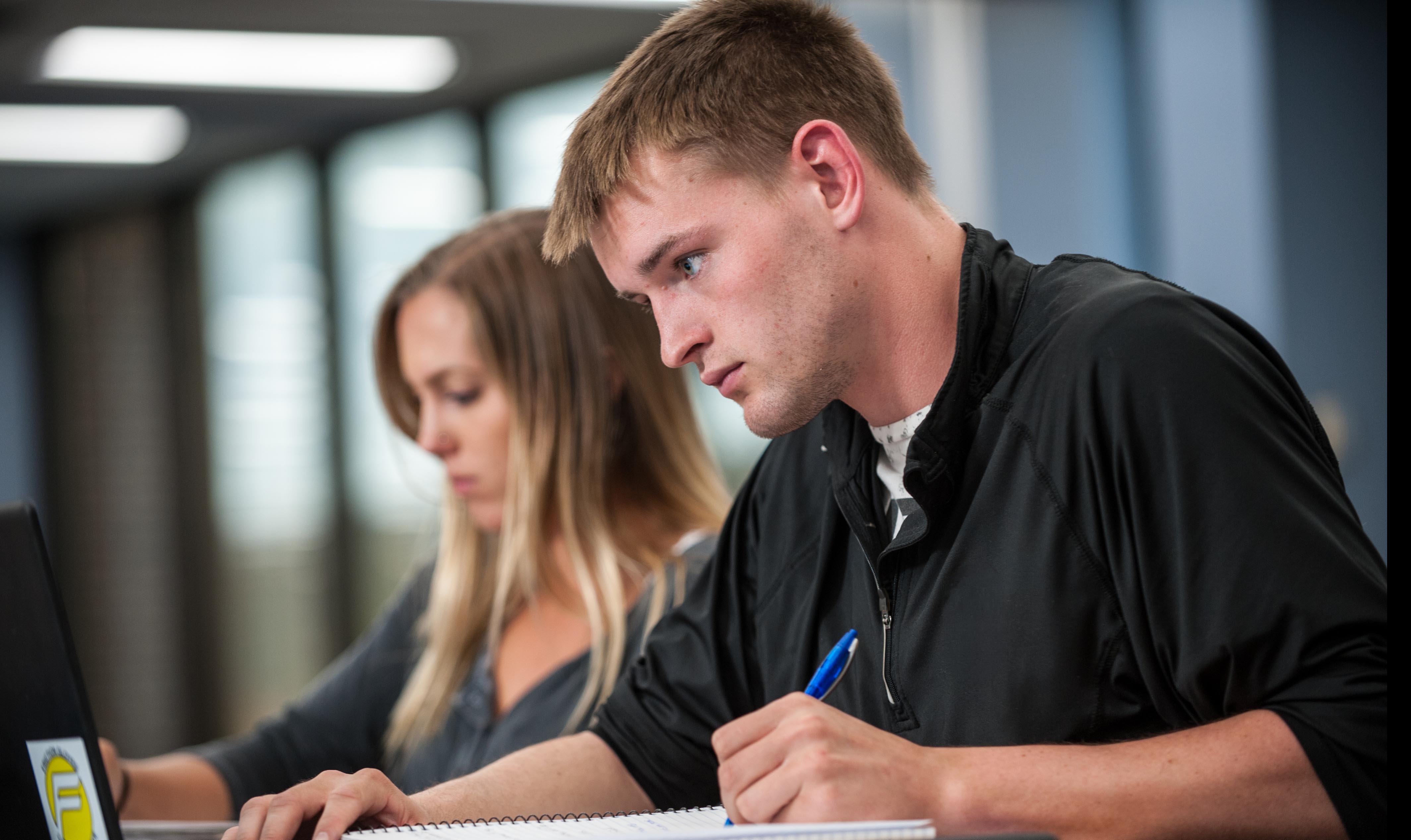 two students working on school work in a classroom
