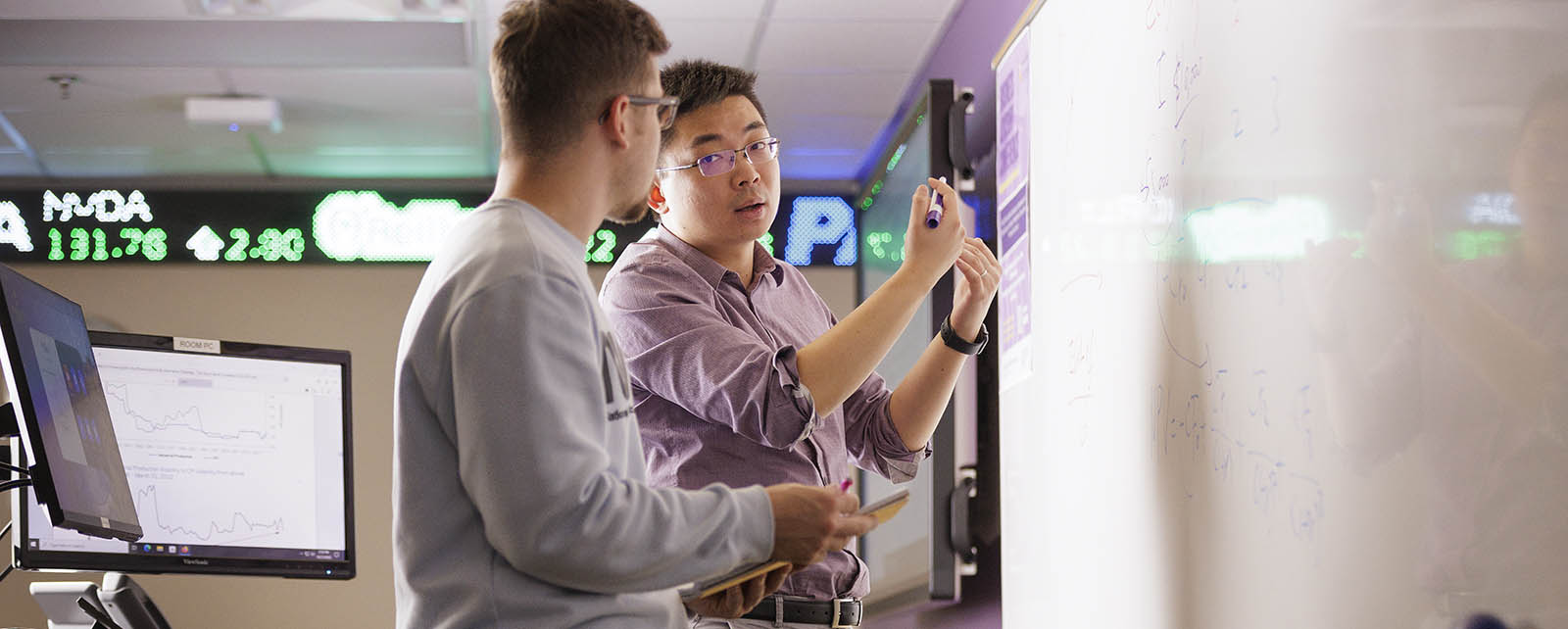 image of professor and student in the finance trading room