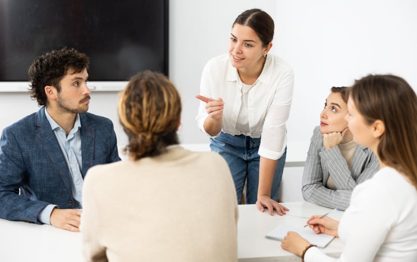 Group sitting around a table talking.