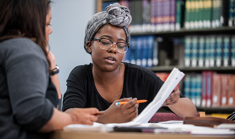 woman holding paper while discussing acceleration and combined degree opportunities