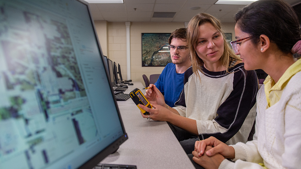 three students looking at satellite view on computer