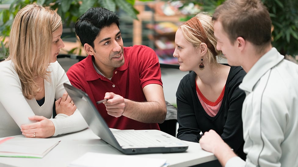students gathered around a laptop