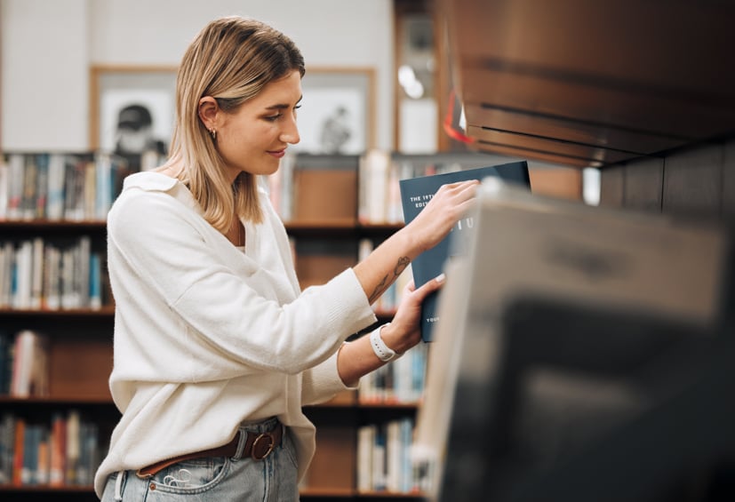 Woman looking for a book in the library.