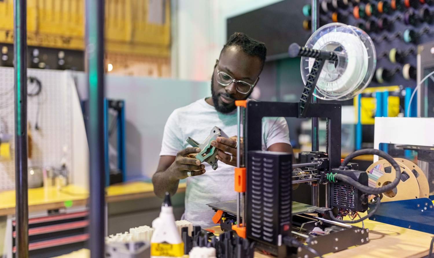 male student working on equipment with technology and tools around him