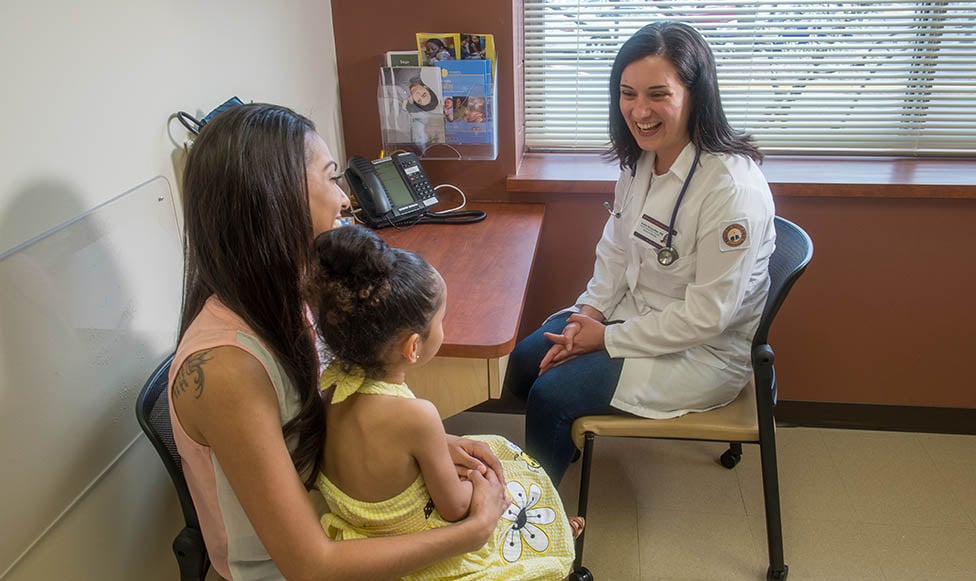 Student Nurse in the nursing simulation lab with a mother and daughter 