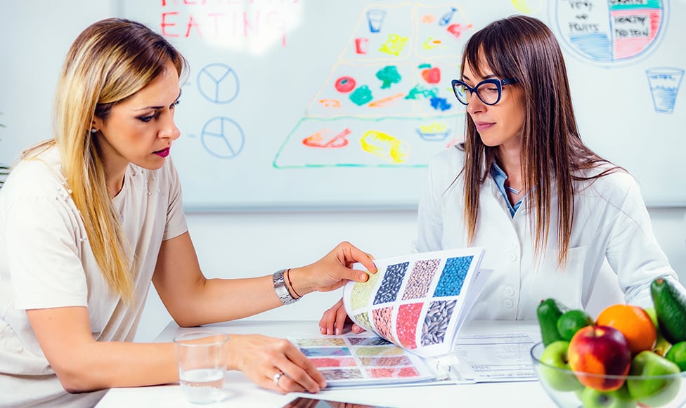 Two women looking through binder.