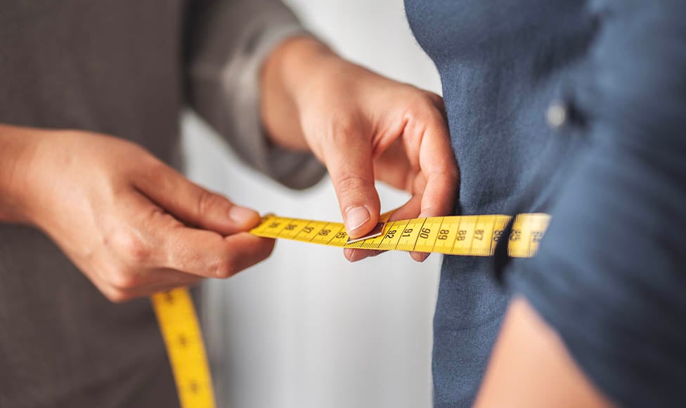 Close up image of a dietician measuring a client's waste