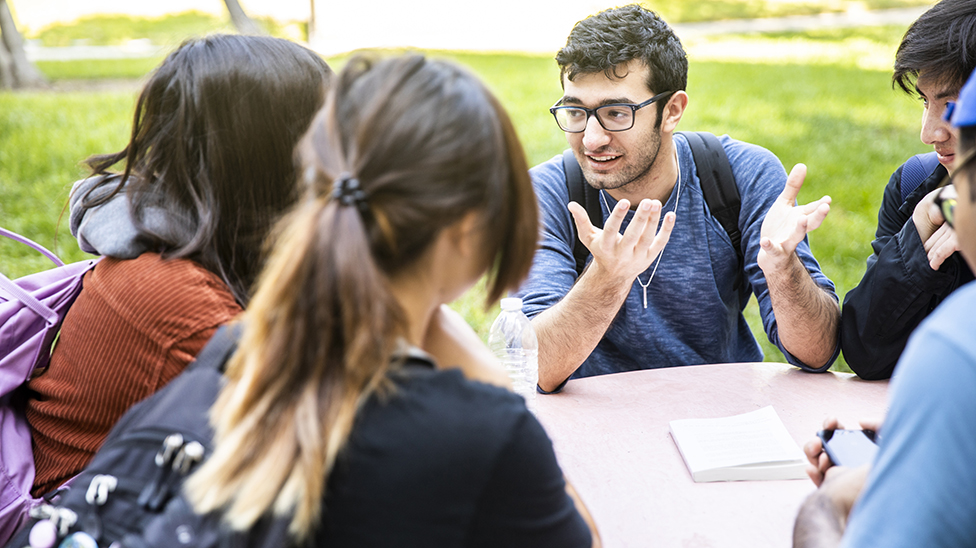 close up of students sitting outside talking