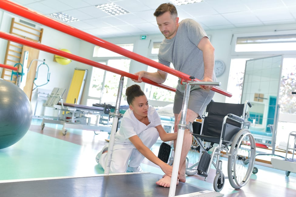 Occupational therapist helping patient walk.