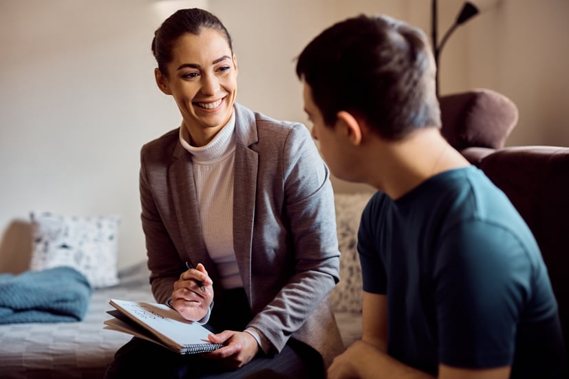 Women talking to teen in therapy session.