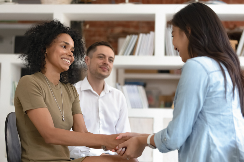 Two women shaking hands.