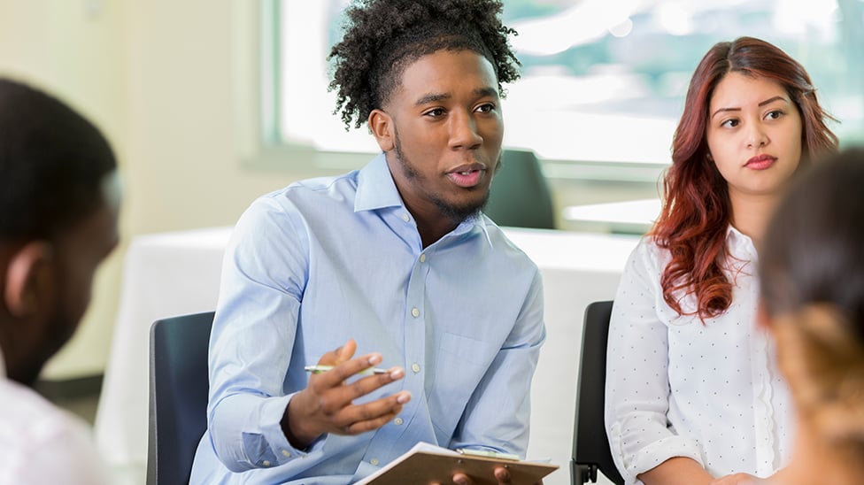 Male student talking to a small group.