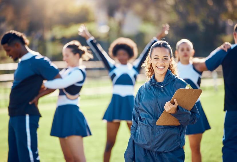 Women coach on the field with athletes.