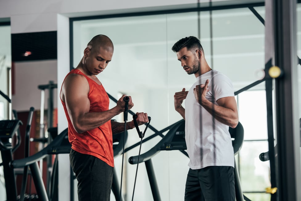 Athletic trainer helping client in the gym.