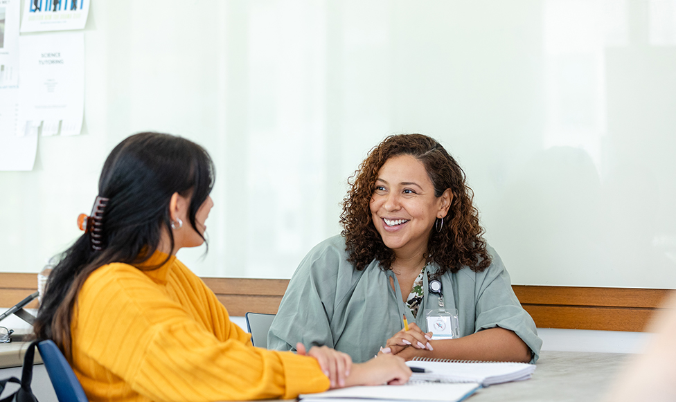 Two women sitting at a table having a conversation.