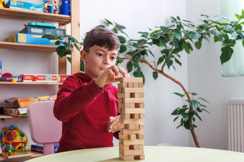 Child building blocks in room.