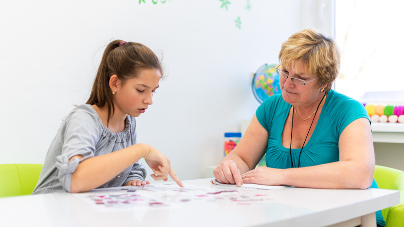 Teacher and student working at a table.