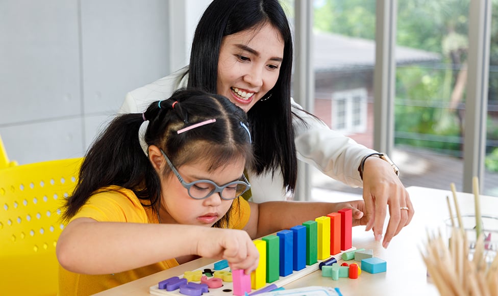 Teacher helping special needs child.